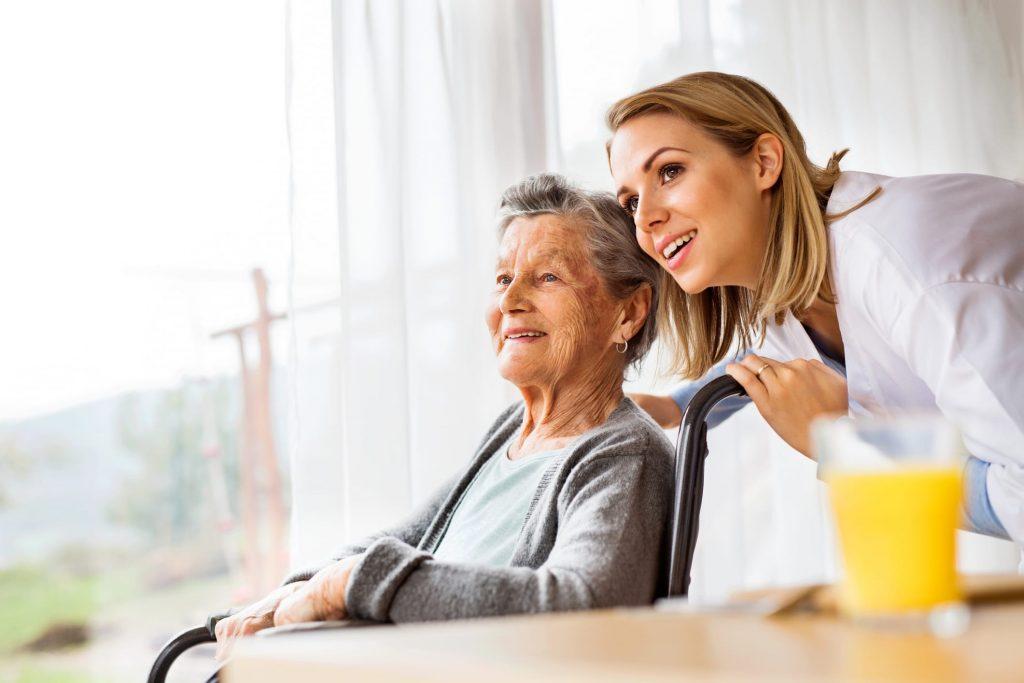 Senior in a wheelchair and her caregiver enjoy the view