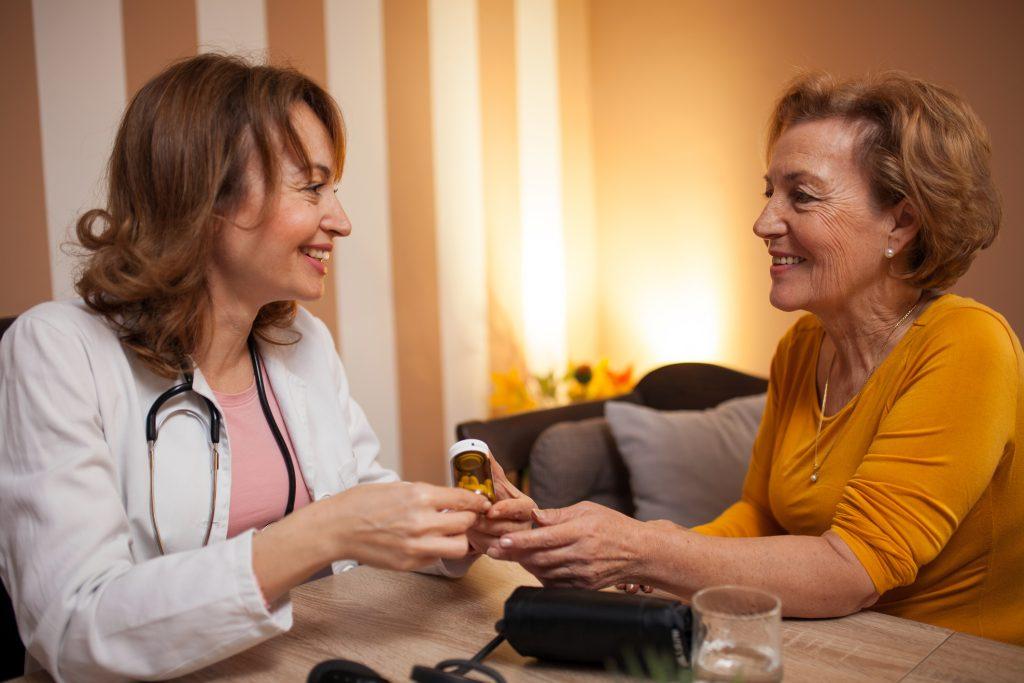 Older woman with a doctor holding a prescription pill bottle