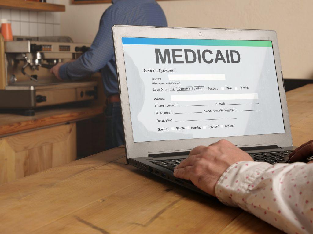 Person researching Medicaid on a laptop